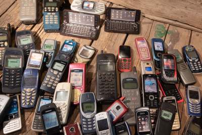 Pile of old 'dumb' mobile phones and old tech equipment