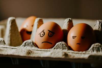 Eggs in egg tray with faces drawn on them