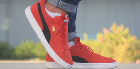 Person's feet in red trainers by Puma