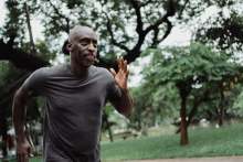 Black man running in forest 