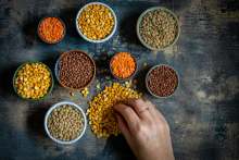 Small pots and piles of dried peas beans and lentils