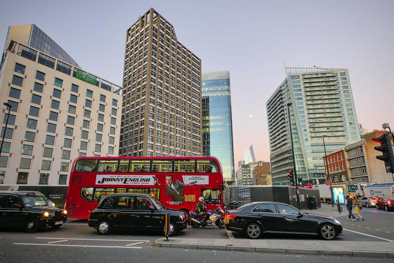 Red double decker bus and cars in UK city