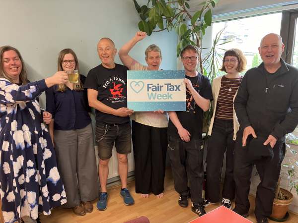 Group of 7 people, holding Fair Tax Week banner