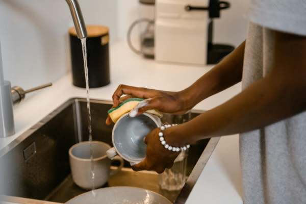 Person washing dishes in sink